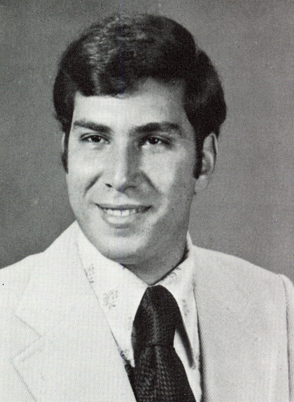 Portrait of Edward Gentile wearing a suit and tie in front of a light background.