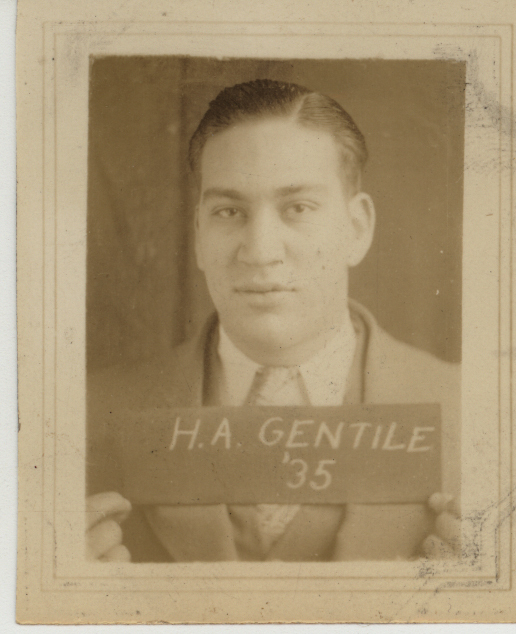 Portrait of Herman Gentile in a suit and tie holding a sign that reads 'H.A. GENTILE '35.'