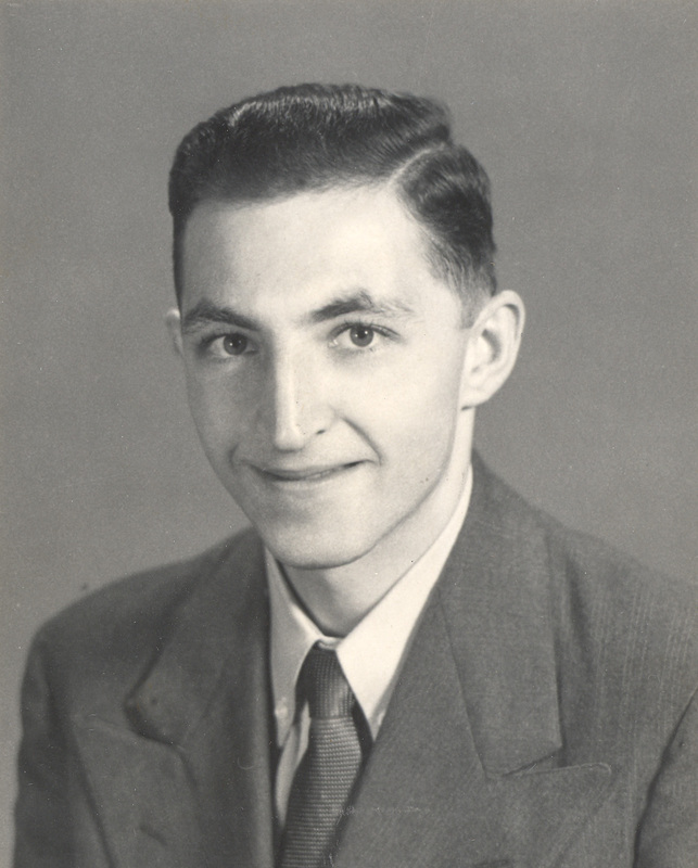 Maurice Greenstein in a suit and tie with neatly combed hair smiling at the camera.