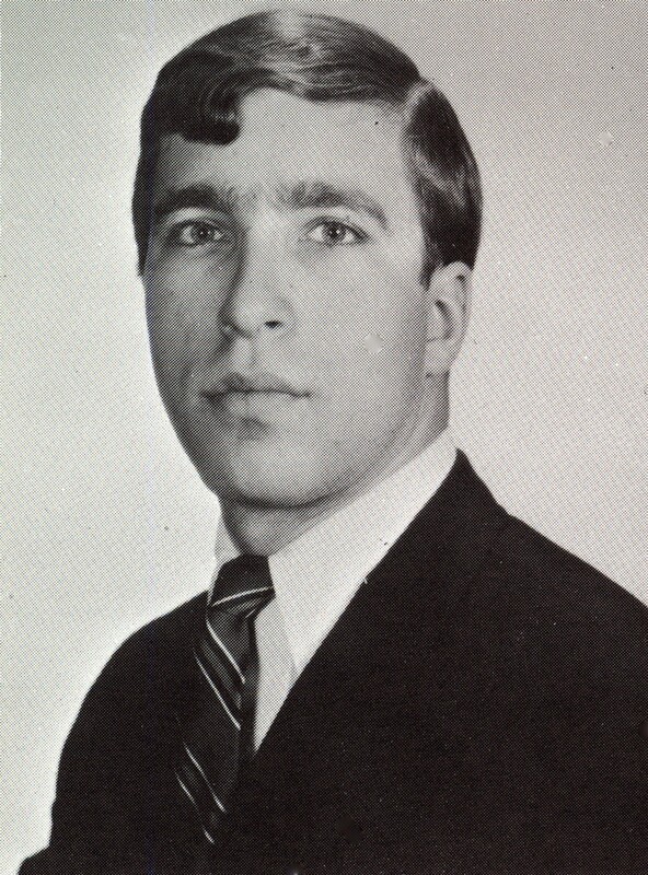 Portrait of Jeffery Blum wearing a suit and tie in front of a light background.