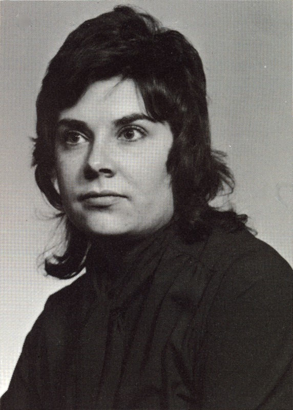 Portrait of Fay Saber wearing black clothes in front of a light background.