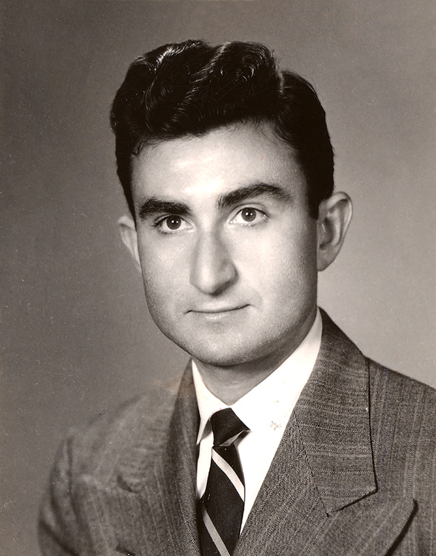 Portrait of Herbert Leshinsky wearing a suit and tie in front of a light background.