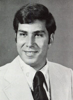 Portrait of Edward Gentile wearing a suit and tie in front of a light background.
