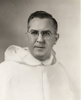 Portrait of Robert Slavin wearing glasses and a white habit with a hood, posed against a plain light background.