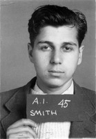 Portrait of Abraham Smith wearing a suit and holding a sign that reads 'A.I. 45 SMITH,' with a plain background.