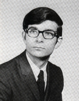 Portrait of Austin Sarat wearing a suit and tie in front of a light background.