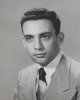 Portrait of Robert Krasner in a light-colored suit jacket, white shirt, and patterned tie.