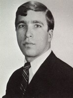 Portrait of Jeffery Blum wearing a suit and tie in front of a light background.
