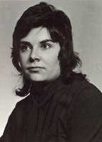Portrait of Fay Saber wearing black clothes in front of a light background.
