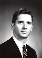 Portrait of Edward Feldstein wearing a suit and tie in front of a light background.