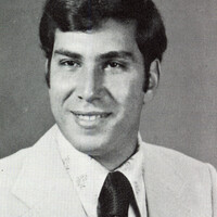 Portrait of Edward Gentile wearing a suit and tie in front of a light background.