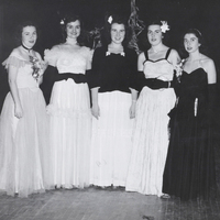 Five women wearing ball gowns pose for a photo.