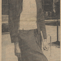 Newspaper photo of a sister in a habit walking along the sidewalk. The text below reads 'Navy blue skirt, jacket, and veil with white blouse form habit of Sisters of Charity of St. Elizabeth, black worn here by Sr. Rose Frederick, S.C., of New York City.'