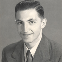 Maurice Greenstein in a suit and tie with neatly combed hair smiling at the camera.