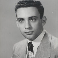 Portrait of Robert Krasner in a light-colored suit jacket, white shirt, and patterned tie.