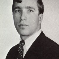 Portrait of Jeffery Blum wearing a suit and tie in front of a light background.