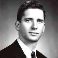 Portrait of Edward Feldstein wearing a suit and tie in front of a light background.
