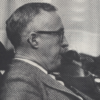 Rev. Paul van K. Thomson smoking from a pipe and wearing a suit.