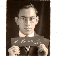 Portrait of Albert Resnick in glasses, suit, and tie holding a sign that reads 'A. Resnick, '43'.