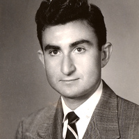Portrait of Herbert Leshinsky wearing a suit and tie in front of a light background.